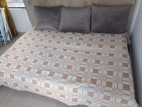 a bed with a brown and white comforter and two pillows at Cobertura com vista pro mar in Cabo de Santo Agostinho