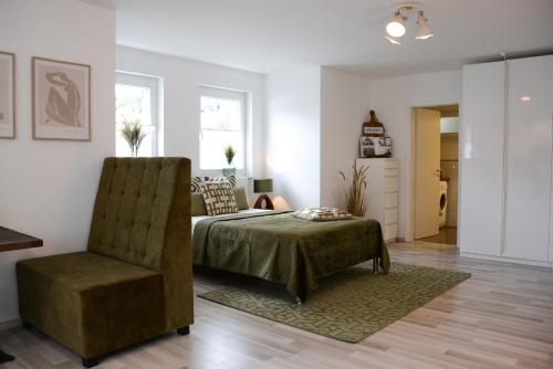 une chambre avec un lit et une chaise dans l'établissement 40qm Wohlfühl-Apartment im Grünen mit Sorglospaket, à Wuppertal