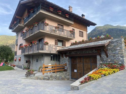 a building with balconies and flowers in front of it at Maison Le Cré Appartamento 2 in Introd