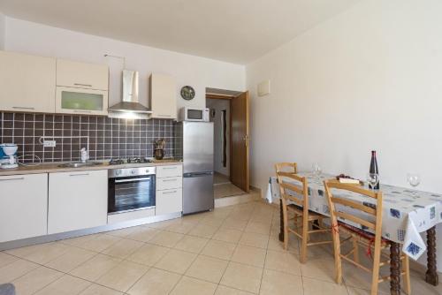 a kitchen with white cabinets and a table with chairs at Federica in Zubovići