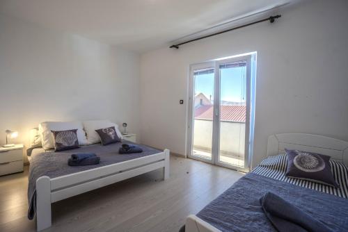 a bedroom with two beds and a large window at Federica in Zubovići