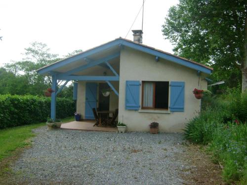 a small white house with a blue roof at Tastet in MouscardÃ¨s