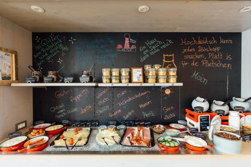 a chalkboard with writing on it next to a table of food at Beach Motel St. Peter-Ording in Sankt Peter-Ording