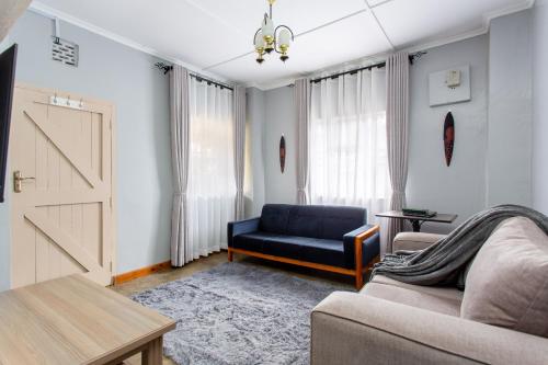 a living room with a blue couch and a door at Yarkona Hedge in Nairobi