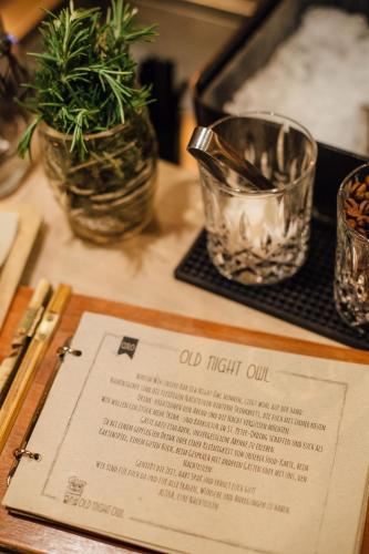 a table with a menu and two glasses and plants at Beach Motel St. Peter-Ording in Sankt Peter-Ording