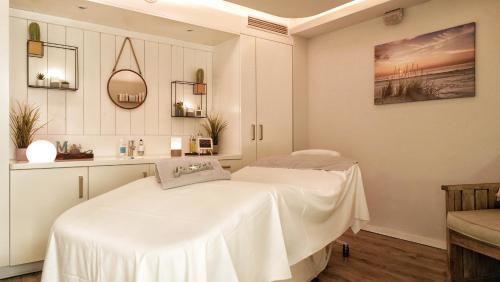 a white room with a bed and a table at Beach Motel St. Peter-Ording in Sankt Peter-Ording