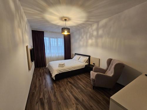 a small bedroom with a bed and a chair at ArtMob Apartment Isaran in Braşov