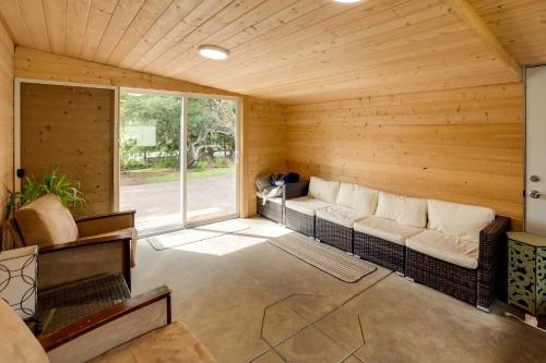 a living room with a couch in a wooden room at Brookings Home with Deck, half Mi to Harris Beach! in Brookings