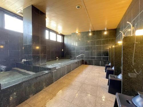 a large bathroom with a large tub and a sink at 釜石駅から徒歩5分ホテルマルエHotelMarue in Kamaishi