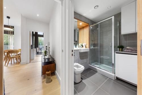 ein Bad mit einem WC und einer Glasdusche in der Unterkunft Trendy 2 bed Flat in Greenwich with Car Parking in London
