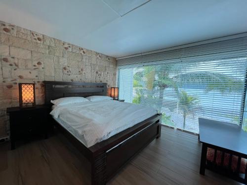 a bedroom with a large bed and a stone wall at Subic Sweet Escape by Bonnie in Olongapo