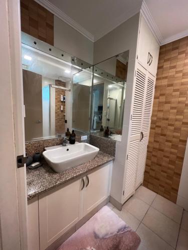 a bathroom with a sink and a large mirror at Subic Sweet Escape by Bonnie in Olongapo