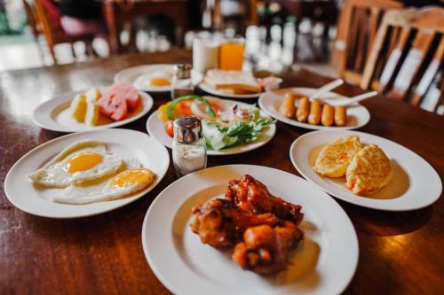 a wooden table with plates of food on it at Coconut Beach Resort, Koh Chang in Ko Chang