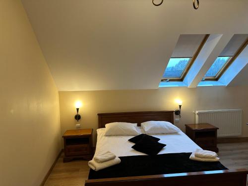 a bedroom with a large bed with two windows at Restauracja i Hotel Oberża Wilczy Głód in Krzyszkowice