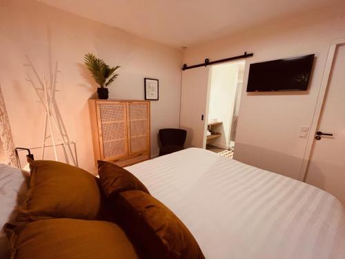 een slaapkamer met een wit bed en een bank bij Bed and Breakfast 013 city in Tilburg