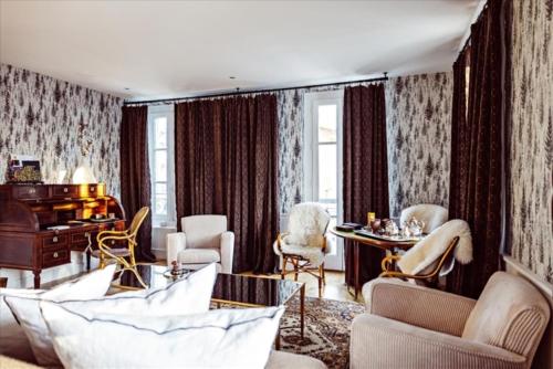 a living room with a couch and chairs and a piano at Grand Hotel Soleil d'Or in Megève