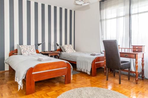 Habitación con 2 camas, escritorio y silla. en 7 Heaven en Belgrado