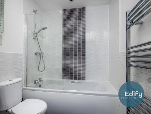 ein weißes Bad mit einer Badewanne und einem WC in der Unterkunft Spacious House With Driveway Parking in Southampton