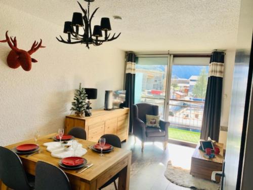 a dining room with a table and chairs and a room with a window at 2 alpes in Les Deux Alpes