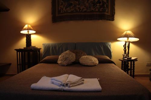 1 cama con 2 toallas y 2 lámparas en Dimora Dei Giganti, en Nápoles