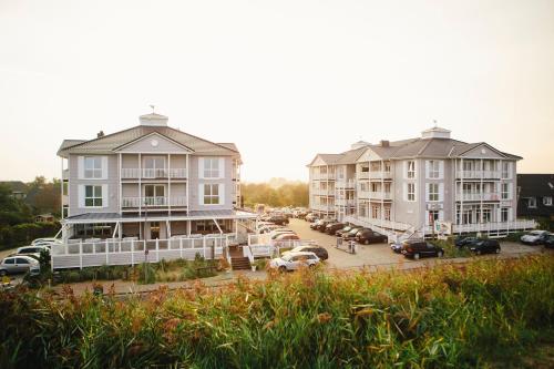a row of houses with cars parked in a parking lot at Beach Motel St. Peter-Ording in Sankt Peter-Ording