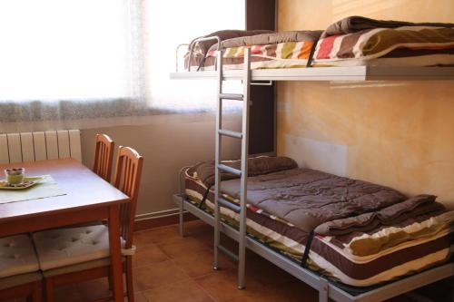 a room with two bunk beds and a table at Apartamento Gis con chimenea in Ribes de Freser