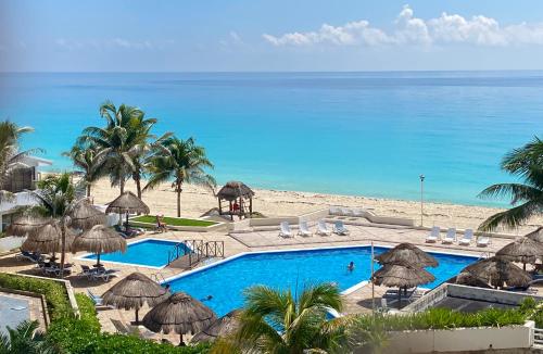 a resort with a swimming pool and a beach at Brisas Shores Beach & OceanFront Apartments 1 or 2 bedrooms Cancun Hotel Zone in Cancún