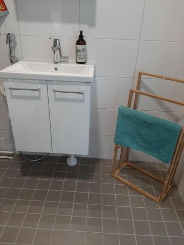 a bathroom with a sink and a chair at Kompakti studio in Tampere