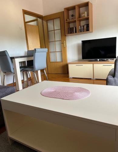 a living room with a table with chairs and a tv at Lara in Banja Luka