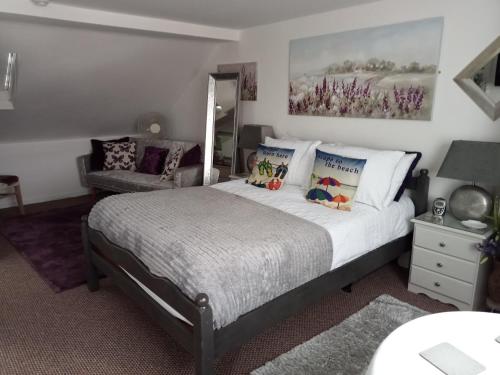 1 dormitorio con cama y sofá en Marjune Guest House en Weymouth