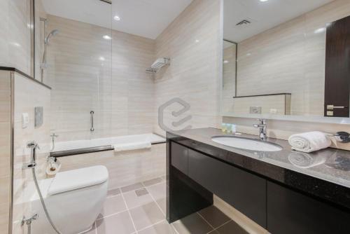 uma casa de banho com um WC, um lavatório e uma banheira em One Bed Apartment in Dubai - Dubai South - Damac Celestia em Dubai