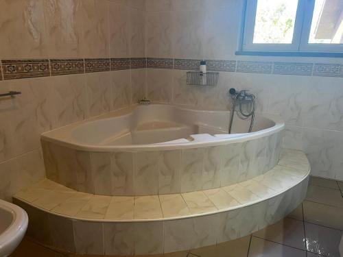 La salle de bains est pourvue d'une baignoire et d'un lavabo. dans l'établissement Quinta das Flores, à Pombal