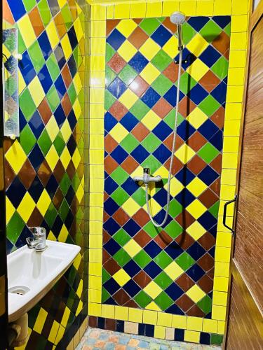 a bathroom with a sink and a colorful tiled wall at Camping auberge palmeraie d'amezrou in Zagora