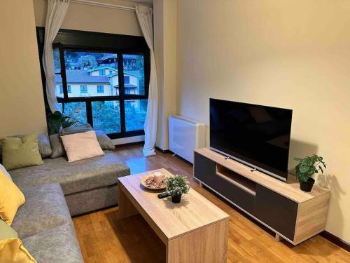 a living room with a large flat screen tv at Apartamento con vistas a la montaña in Infiesto