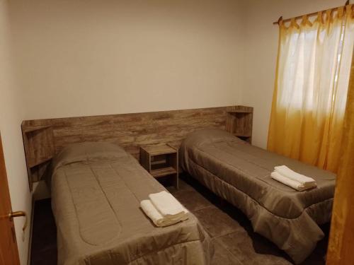 1 dormitorio con 2 camas y ventana con toallas en Alojamiento Mesas en San Rafael