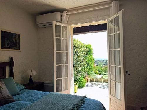 une chambre avec une porte ouverte sur un patio dans l'établissement Mas Flora, à La Croix-Valmer