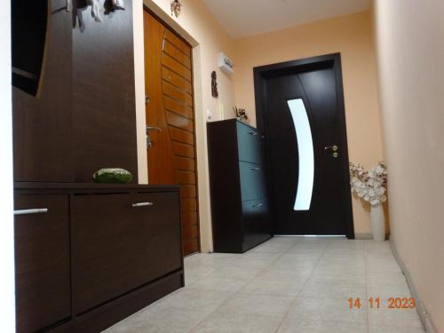 a hallway with a black door and a dresser at АЛЕКСАНДРА in Kyustendil