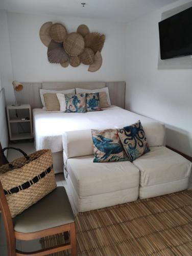 ein Wohnzimmer mit einem Sofa und einem Bett in der Unterkunft Apartamento no Hotel Porto Marina Mangaratiba in Mangaratiba