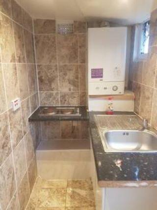 a small kitchen with a sink and a counter at A LOVELY STUDIO FLAT FEW MINTUES TO DAGENHAM EAST STATION in Dagenham