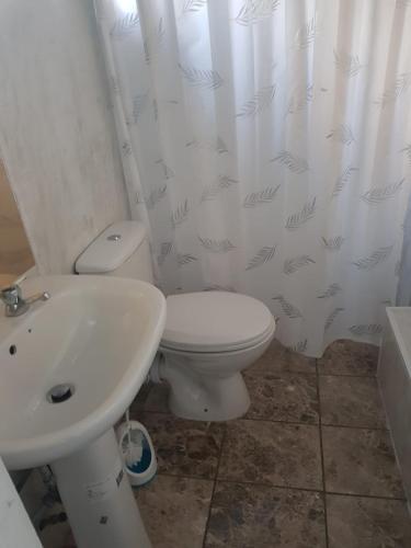 a bathroom with a white toilet and a sink at A LOVELY STUDIO FLAT FEW MINTUES TO DAGENHAM EAST STATION in Dagenham