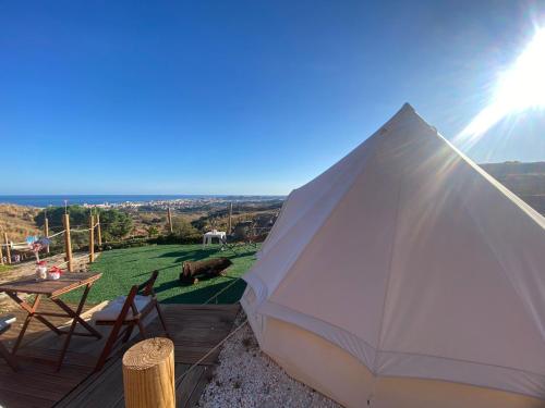 a white tent with a table and chairs on a deck at Glamping Finca el Olivo in Mijas
