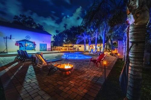 a patio with chairs and a pool at night at Tropical Oasis- Pickleball, Pool, Hot Tub- 15 min to beach in Melbourne