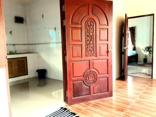 a red door in a room with a kitchen at Central Essence in Haad Chao Phao