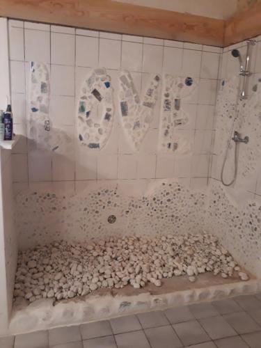 a bathroom with a bath tub covered in rocks at Un jardin sur la colline in Claveyson