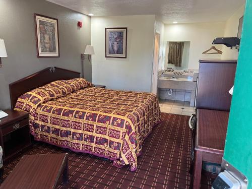 Habitación de hotel con cama y lavabo en EXECUTIVE INN, en Fort Worth