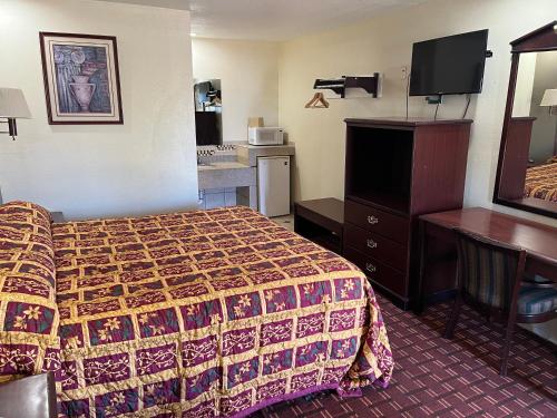 Habitación de hotel con cama y escritorio en EXECUTIVE INN, en Fort Worth