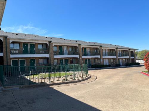 un edificio de apartamentos con una valla delante en EXECUTIVE INN, en Fort Worth