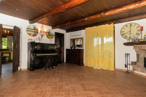 uma sala de estar com um piano e um relógio na parede em Guest House: Casa dei Lillà em Bellegra