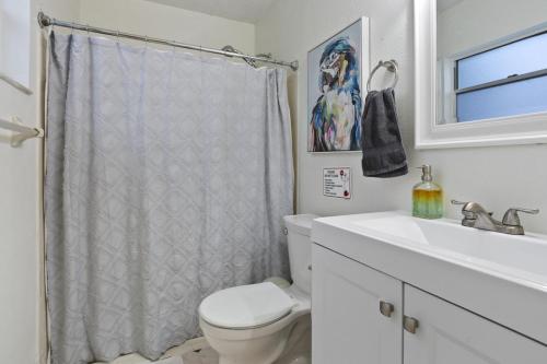 a white bathroom with a toilet and a sink at Tropical Oasis FL Pinellas Park in Pinellas Park