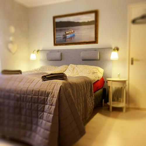 a bedroom with a bed and a painting on the wall at Photoeverhome in Bengtsfors